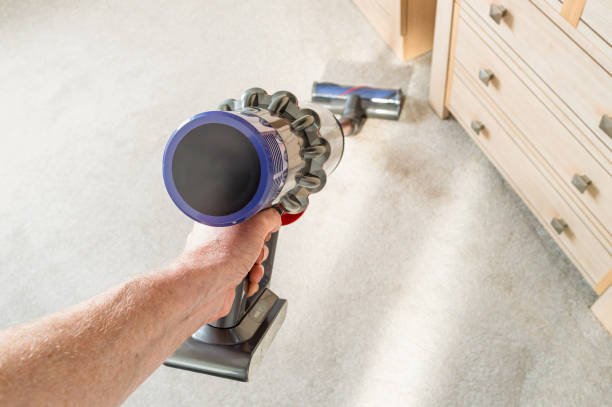 A person using a pet Dyson pet vacuum on the floor